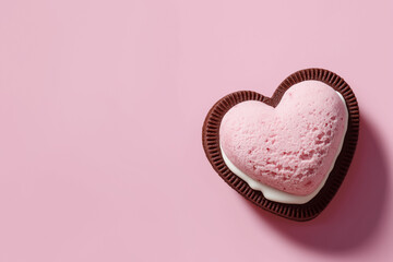 Heart shaped cookie with pink mousse on a pink background perfect for valentines day graphics and food related designs, sweet treats.