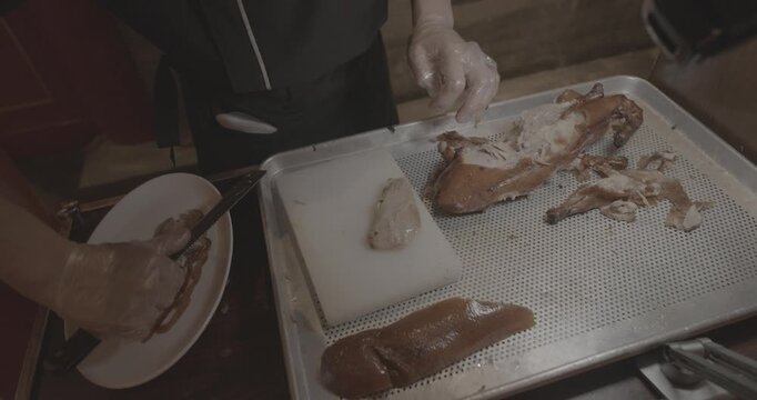 chef skillfully Peking duck slices succulent meat for an eager crowd, showcasing expertise.