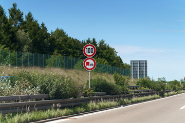 On the Autobahn near Freiburg in Germany, speed limit signs warn drivers of a 100 km/h restriction...
