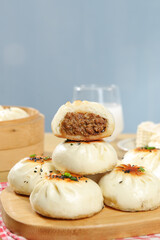 Delicious Chinese Steamed Buns with Beef Filling - Traditional Asian Breakfast Snack on Wooden Plate