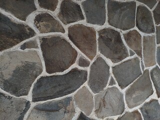 Rustic Stone Wall with Irregular Dark Stones and Thick White Mortar