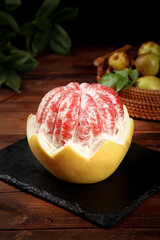 Fresh Cut Pomelo Fruit with Pink Flesh on Dark Slate