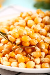 Fresh Golden Popcorn Kernels on White Plate with Spoon