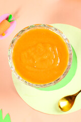 Carrot Puree for Babies in Glass Jar on Pastel Background