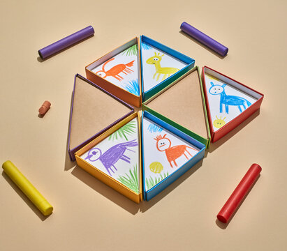 Soft angled light illuminating colorful triangular boxes and scattered crayons