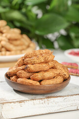 Fresh wet red skin peanuts in shell in wooden bowl on rustic table