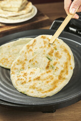 Homemade Scallion Pancakes Cooking in Pan with Wooden Spatula - Traditional Asian Flatbread Making Process