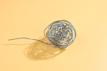 Steel wire coil on a yellow background.
