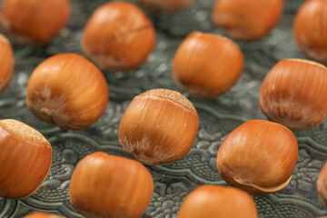Hand-peeled hazelnuts with dried shells showcase natural nut kernels on textured surface