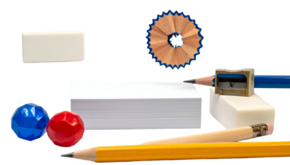 School supplies arrangement on black background, featuring pencils, erasers, paper, and shavings