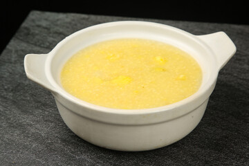 Healthy Yellow Porridge or Soup in White Ceramic Bowl on Dark Kitchen Counter