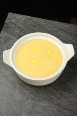 Healthy Yellow Porridge in White Bowl on Granite Counter - Nutritious Breakfast Meal