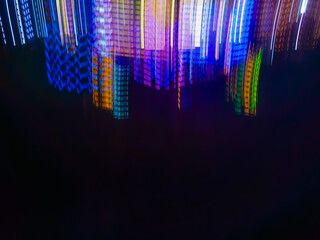 An abstract image of bright light particles moving in the darkness of the night, creating a dynamic...