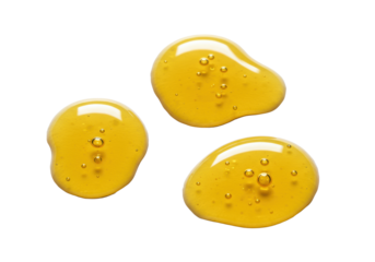 Three viscous golden-yellow liquid drops, resembling pure honey, with air bubbles and glossy surface, on bright white background with shallow DOF, 100mm macro. Concept of natural sweetness and purity