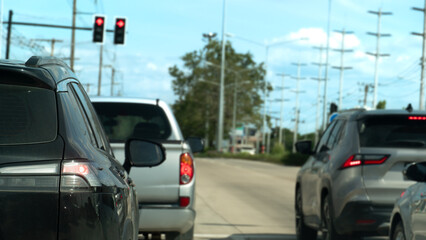 Rear side of black car with turn on brake light. Stop on concrete road by traffic red light...