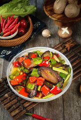 Fried Bacon and Vegetable Stir Fry with Bell Peppers on Rustic Wooden Kitchen Table