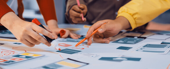 Engaging scene of diverse hands actively participating in a creative brainstorming session for a digital project, showcasing vibrant markers and sketches on a tabletop. SACTR