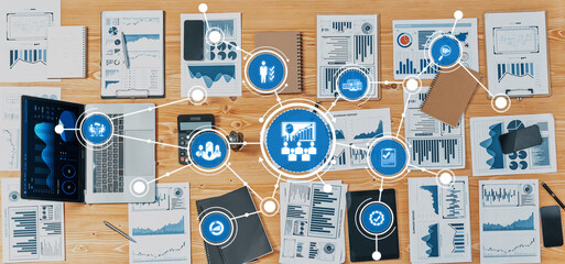 This image showcases a dynamic business management setting with data analysis and strategic planning materials spread across a wooden desk, ideal for professionals. Amity