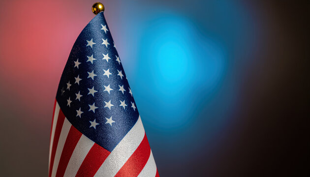 Small handheld national flag waving against soft red and blue bokeh lighting, patriotic symbolism with textured fabric and gold finial conveying pride and celebration