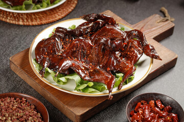 Spicy Marinated Roasted Quail Ready to Eat Served Cold on Wooden Board with Fresh Lettuce