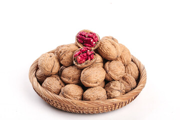 Fresh Xinjiang Walnuts in Wicker Basket on White Background with Cracked Nut Showing Red Kernel