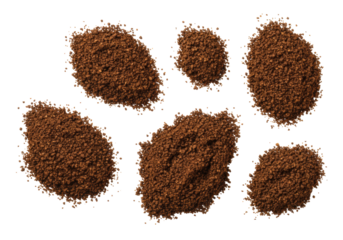 Macro flat lay of dark brown granular piles, resembling ground coffee or black pepper, varying in size, on a transparent background with copy space, bright studio lighting. Culinary texture concept