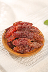 Red Xinjiang Raisins in Wooden Bowl - Premium Dried Fruit Snack on White Background