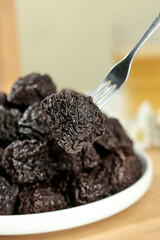 Dried Prunes Plums on Fork from Bowl Healthy Snack Food Closeup