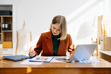 Female designer choosing a color palette while working on a creative project in a bright modern workspace.