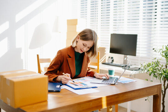 Female designer choosing a color palette while working on a creative project in a bright modern workspace. - Powered by Adobe