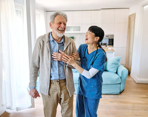 Doctor or nurse caregiver helping senior man walking  at home or nursing home