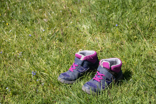 chaussures de marche pour enfant abandonn&eacute;e dans l'herbe, marcher pieds nus