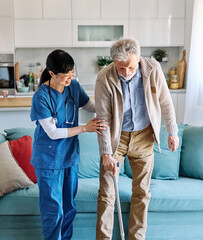 Doctor or nurse caregiver helping senior man walking  at home or nursing home