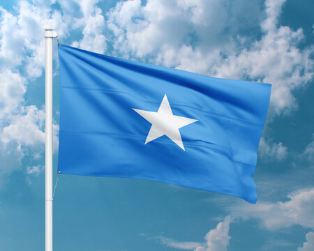 Realistic close-up of the Somalia flag waving on a tall flagpole under a bright sky with soft scattered clouds, showing smooth wind motion, vivid blue colors, and a clear atmosphere of national pride.