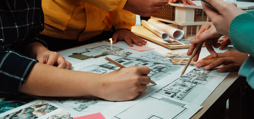 A diverse team engages in a collaborative design session, working together on detailed architectural blueprints and sketches while brainstorming innovative ideas. SACTR