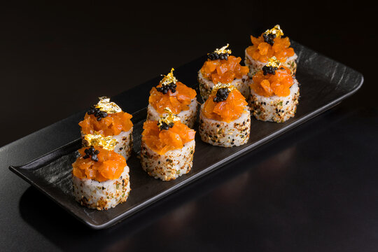 Elegant sushi rolls topped with spicy salmon, black caviar, and luxurious gold leaf flakes