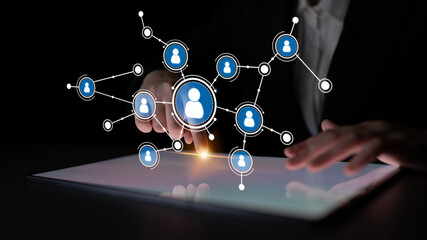 A conceptual image showcasing digital interaction with user icons arranged in a network. The scene highlights a hand touching a touchscreen display, symbolizing connectivity. Tessel