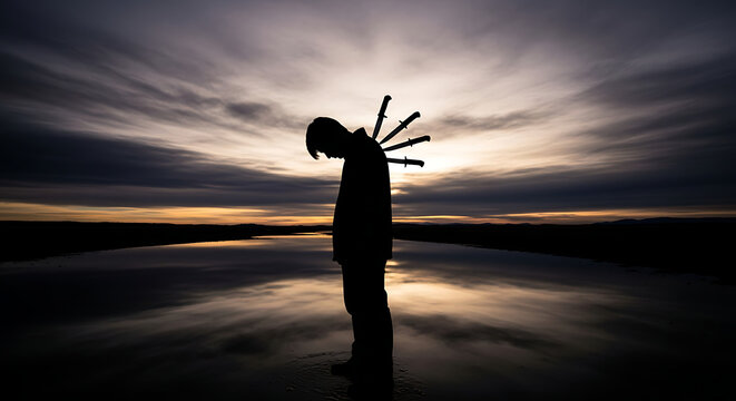 Conceptual silhouette of a person suffering from betrayal with swords stabbed in their back