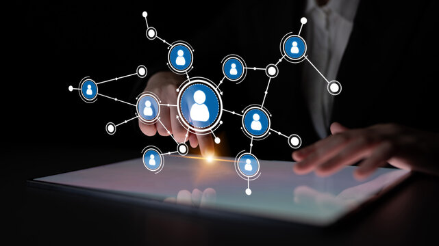 A conceptual image showcasing digital interaction with user icons arranged in a network. The scene highlights a hand touching a touchscreen display, symbolizing connectivity. Tessel