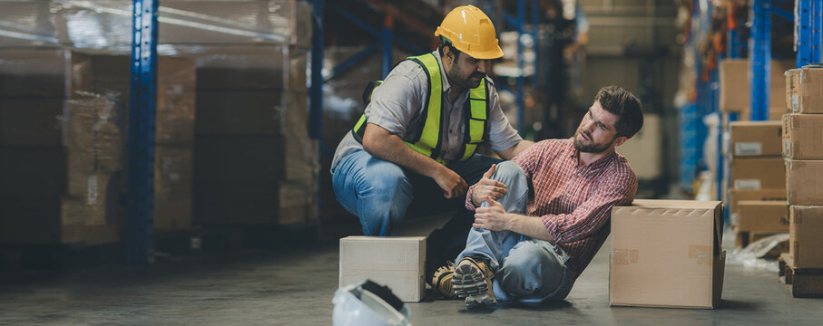 First aid support accident at work of worker at factory. Male worker has an accident on the floor in warehouse site - Powered by Adobe