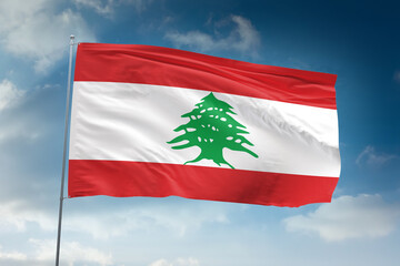 Realistic close-up of the Lebanon flag waving on a tall flagpole under a bright sky with soft scattered clouds, showing smooth wind motion, vivid colors, and a clear atmosphere of national pride.
