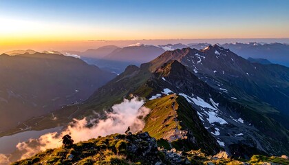 High altitude sunrise paints the mountain peaks. Clouds dance on the slopes with jagged rocks and snow patches