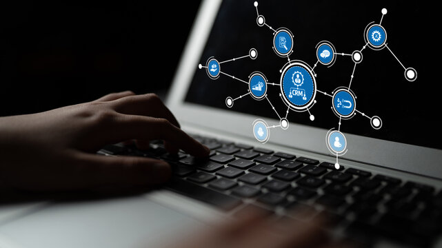 A close-up view of hands typing on a laptop keyboard displaying abstract digital icons that signify technology, networking, and online communication amidst a dark setting. Tessel