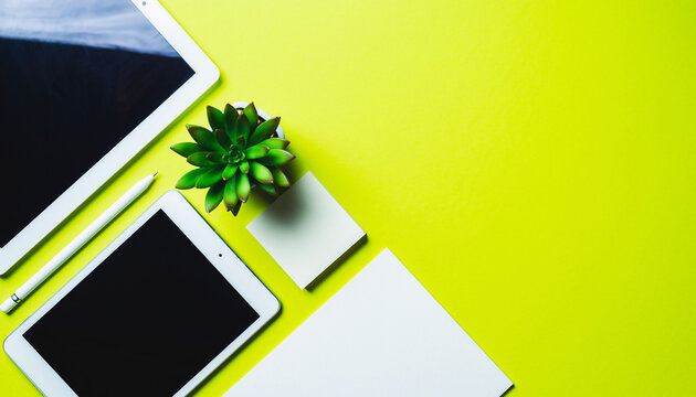Modern workspace setup featuring tablets, succulent, and stationery for creative professionals and digital workflow visual appeal, vibrant and productive