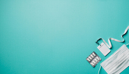 Essential Workplace Safety Flat Lay Featuring Face Mask, ID Badge, and Medication for Employee Health and Well-being During Flu Season and Health Crisis