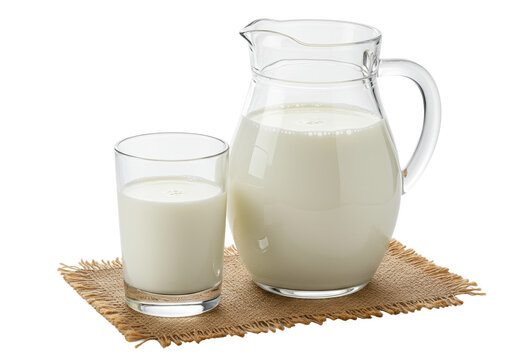A clear glass pitcher and tumbler of creamy white milk with tiny air bubbles on a rustic brown burlap mat, against a transparent background with copy space, concept of healthy dairy