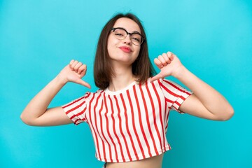 Young Ukrainian woman isolated on blue background proud and self-satisfied