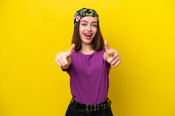 Young Ukrainian woman isolated on yellow background surprised and pointing front