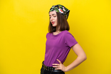 Young Ukrainian woman isolated on yellow background suffering from backache for having made an effort