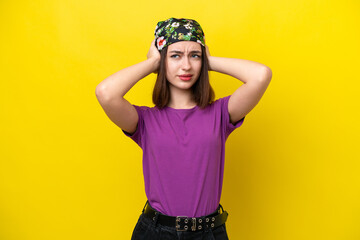 Young Ukrainian woman isolated on yellow background frustrated and covering ears